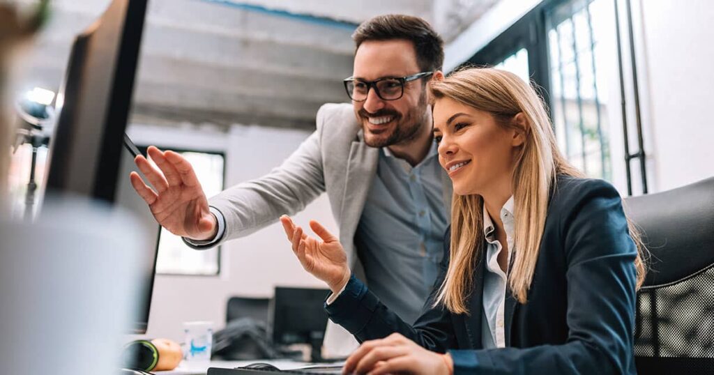 Business colleagues looking at computer screen