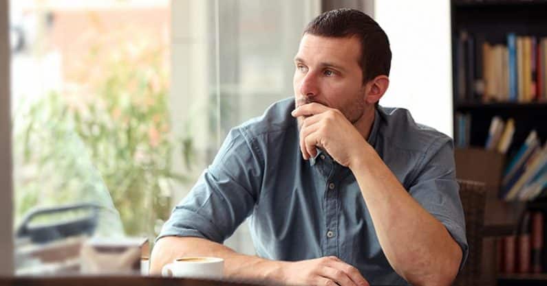 Man sitting in thought with hand on chin