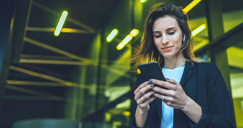 Woman using phone outside commercial building